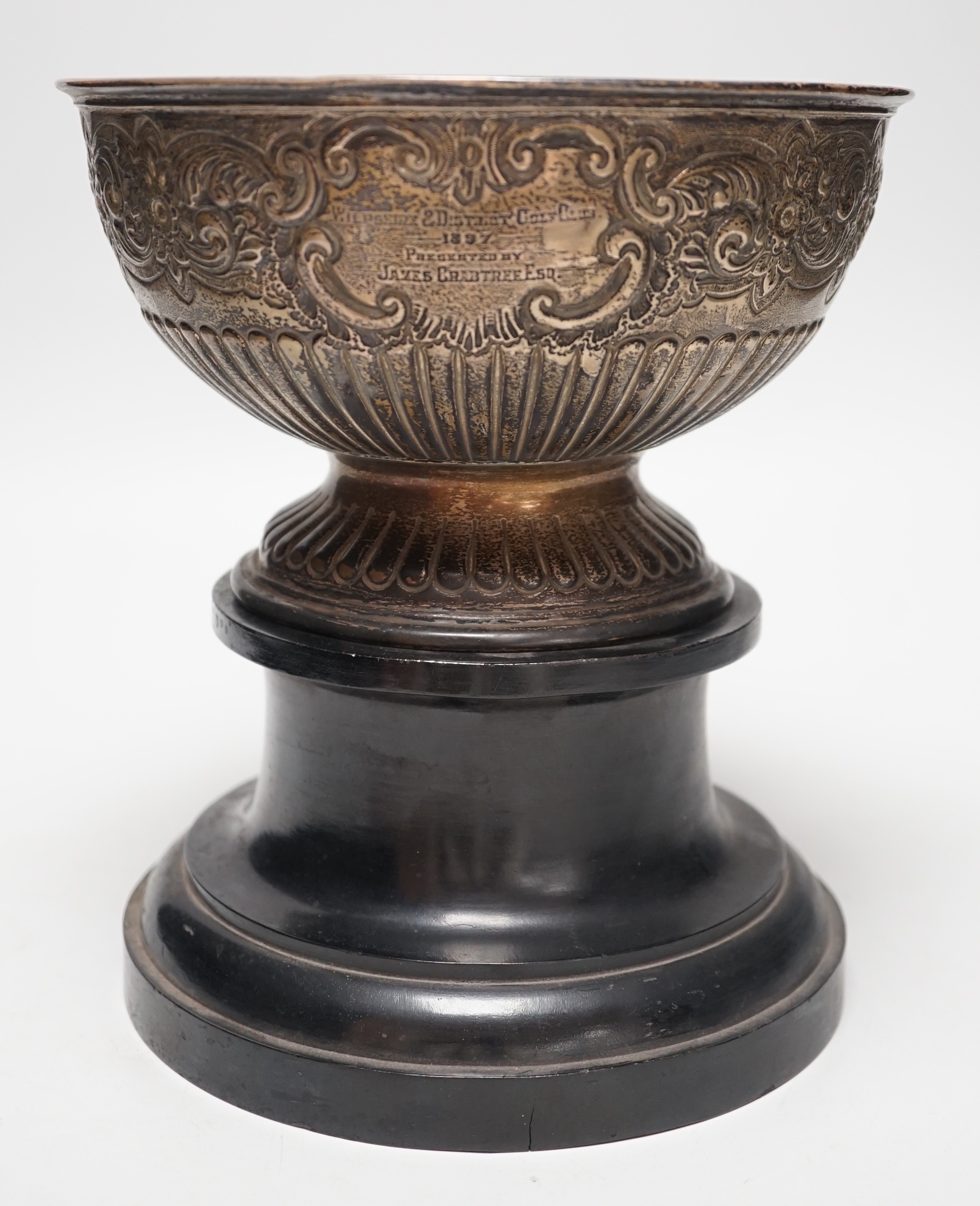 A late Victorian demi fluted and embossed silver presentation rose bowl, with engraved inscription, James Deakin & Sons, Sheffield, 1896, diameter 19.5cm, 12.2oz, on ebonised plinth